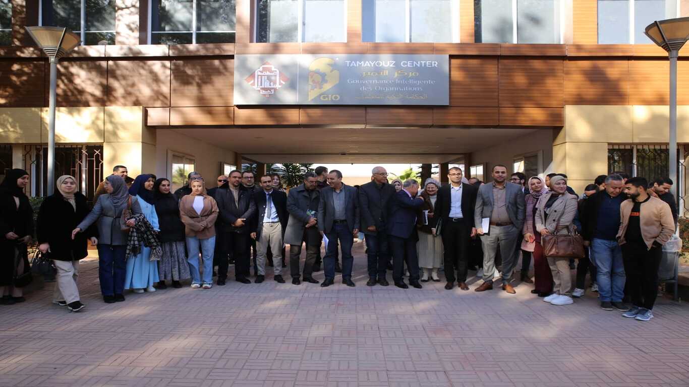 صورة جماعية تضم المشاركين في المائدة المستديرة حول الجهوية المتقدمة بالمغرب، ملتقطة أمام قاعة التميز بكلية الحقوق بوجدة، مع ظهور شعار الكلية في الخلفية