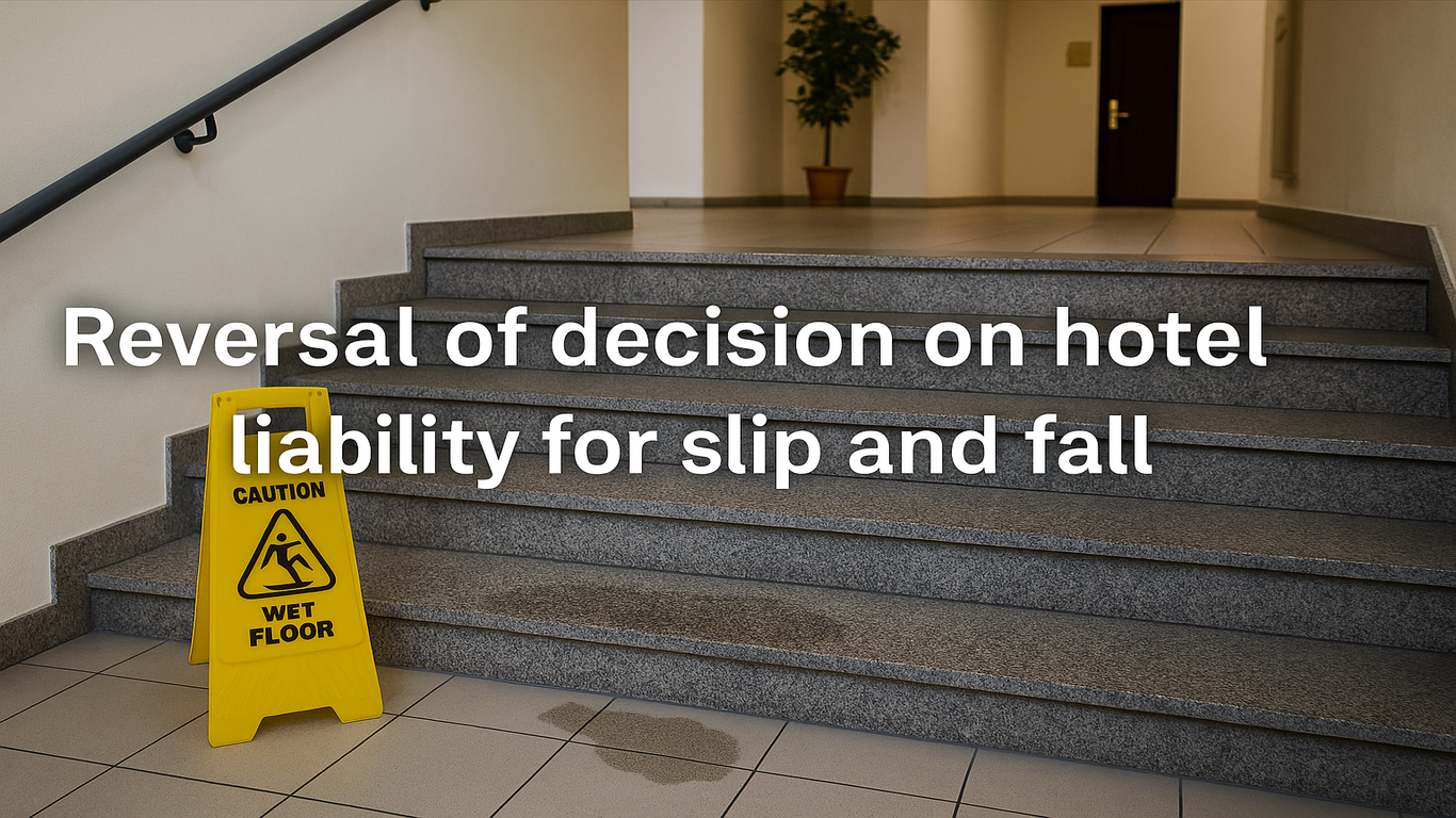 درج فندق مبلل مع لافتة تحذيرية صفراء مكتوب عليها "أرضية مبللة"، يعكس مسؤولية الفندق عن حادث انزلاق محتمل.