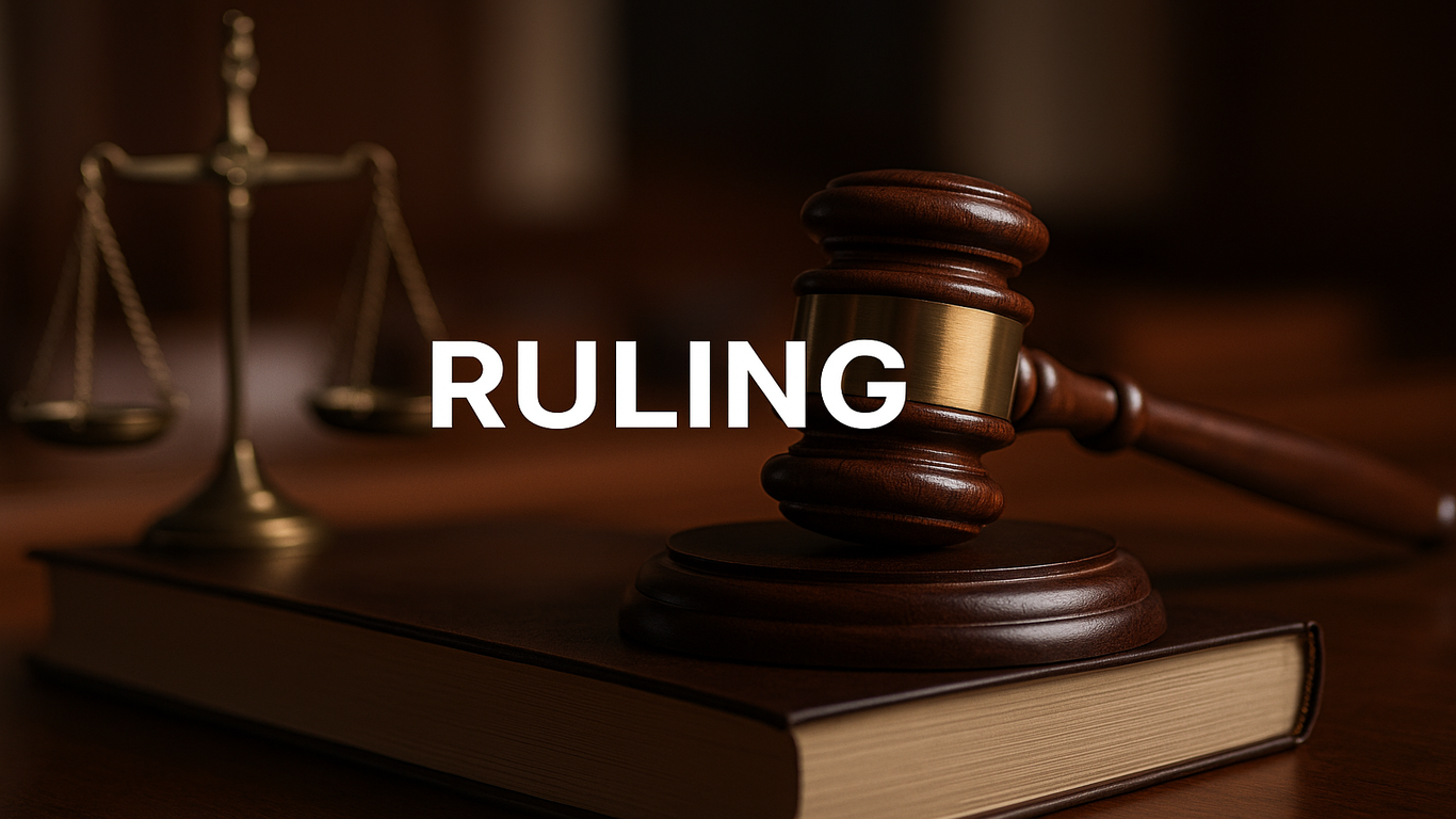 مطرقة قاضٍ على كتاب قانوني مع ميزان العدالة في الخلفية وكلمة "RULING" مكتوبة في المنتصف